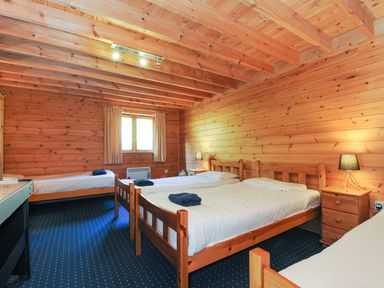 A bedroom with multiple beds and wooden interior at Eden St Breward