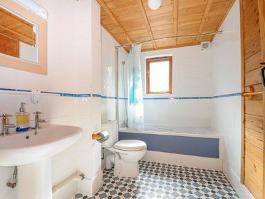 A bathroom with a basin, toilet, bathtub, and shower at Heligan in St Breward