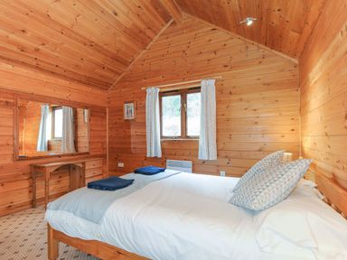 A bedroom with wooden walls and a bed at Heligan St Breward