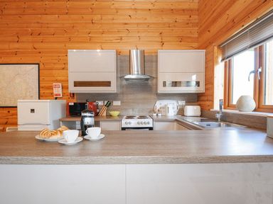 A kitchen with a fridge, cooker, and coffee maker at Polzeath in St Breward