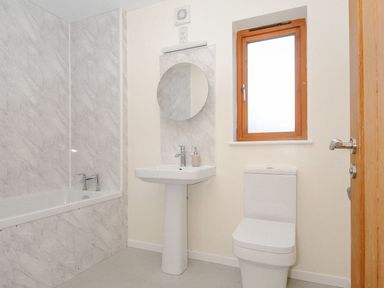 A bathroom with a bathtub, sink, and toilet at Polzeath in St Breward