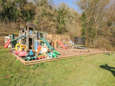 An outdoor playground with slides and toys at Polzeath St Breward