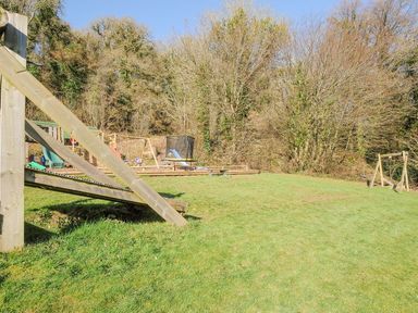 An outdoor playground with a slide and trampoline at Polzeath in St Breward
