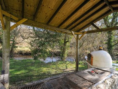 An outdoor grill area next to a stream at Polzeath in St Breward