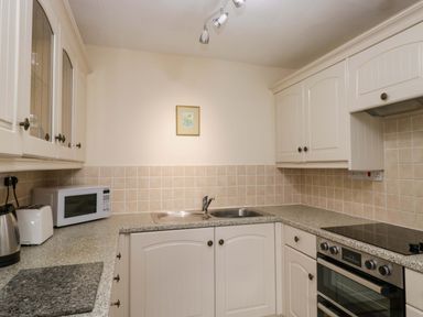 A kitchen with cabinets, sink and appliances at Buckbarrow Seascale