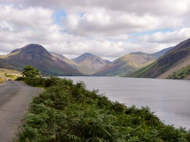A landscape view featuring a lake surrounded by mountains and a road at Buckbarrow Seascale