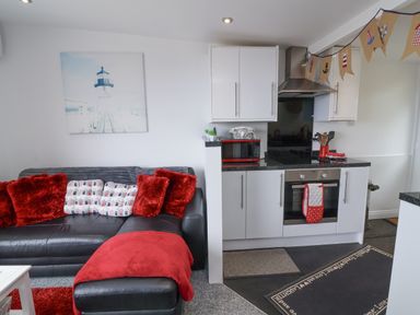 A kitchen area with a sofa and kitchen appliances at I C Lundy Too near Bideford Bay Holiday Park