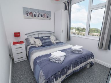 A bedroom with a bed and window at I C Lundy Too Bideford Bay Holiday Park near Woolfardisworthy