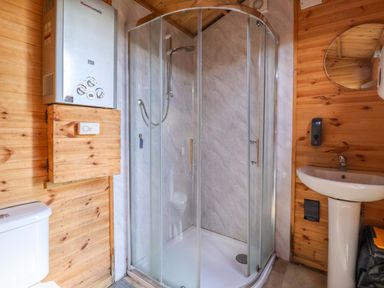 A bathroom with a shower, toilet, and sink at Shepherds hut