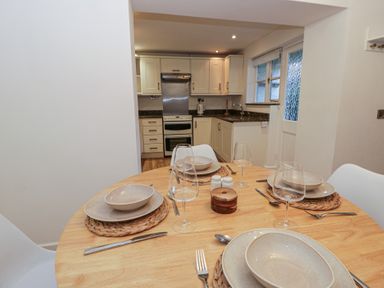 A kitchen with a dining table set for a meal at Cariad Cottage in Hereford