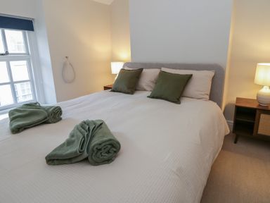 A bedroom with a double bed and bedside tables at Cariad Cottage in Hereford