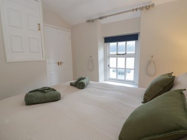 A bedroom with a bed and towels at Cariad Cottage Hereford