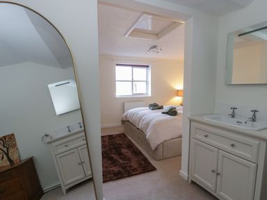 A bedroom with a bed and sink at Cariad Cottage Hereford