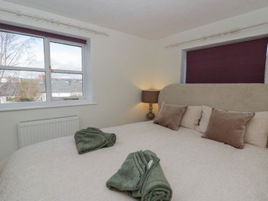 A bedroom with a bed and lamp at Cariad Cottage Hereford
