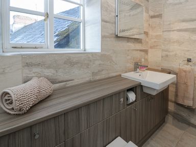 A bathroom with a sink and mirror at Cariad Cottage in Hereford