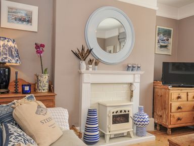 A living room with a sofa and fireplace at Mayhurst in Looe