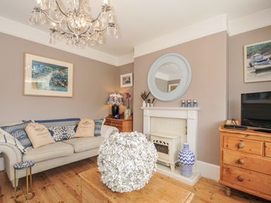 A living room with a sofa and coffee table at Mayhurst in Looe