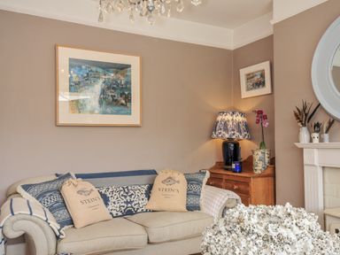 A living room with a sofa and lamp at Mayhurst in Looe