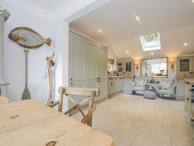A kitchen with a dining table and cushioned seating at Mayhurst in Looe