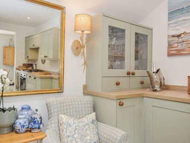 A kitchen with cabinets and a mirror at Mayhurst in Looe
