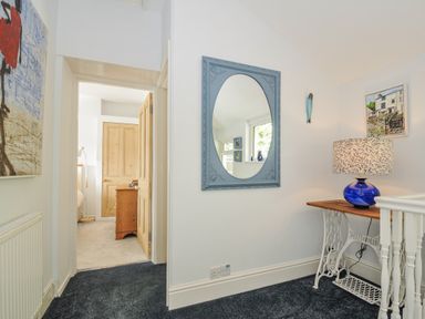 A hallway with a mirror and lamp at Mayhurst Looe
