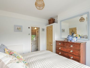 A bedroom with a bed and dresser at Mayhurst in Looe