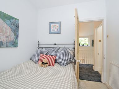 A bedroom with a bed and artwork at Mayhurst in Looe