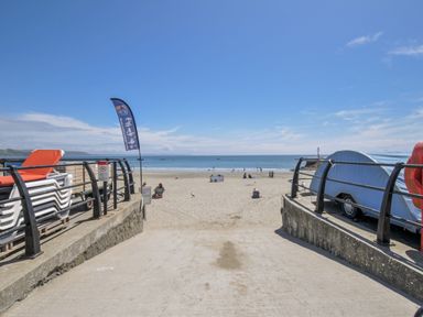 A beach view with people near the sea at Mayhurst in Looe