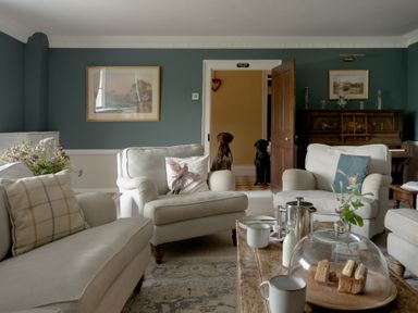 A living room with a coffee table and dogs at Holwell Farmhouse in Bampton