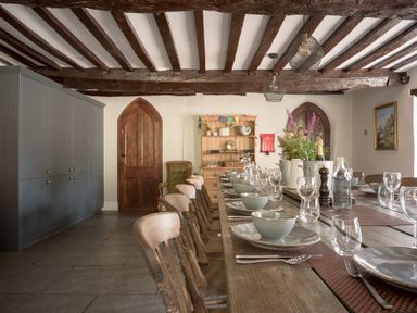 A dining room with a long table set for meals at Holwell Farmhouse in Bampton