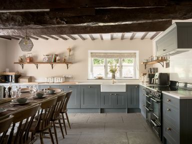 A kitchen with a dining table and shelves at Holwell Farmhouse in Bampton