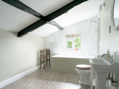 A bathroom with a bathtub and sink at Holwell Farmhouse in Bampton