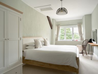 A bedroom with a bed and wardrobe at Holwell Farmhouse in Bampton