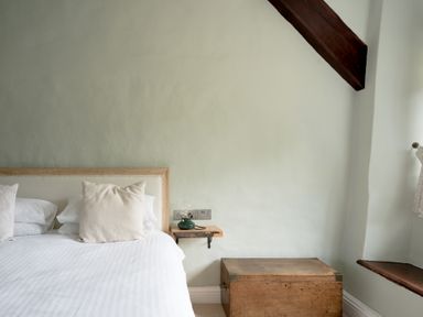 A bedroom with a bed and wooden chest at Holwell Farmhouse in Bampton