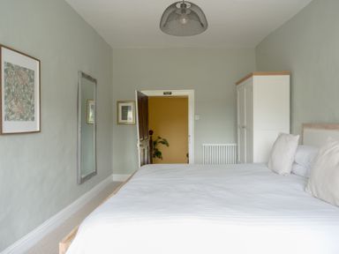 A bedroom with a bed and mirror at Holwell Farmhouse in Bampton