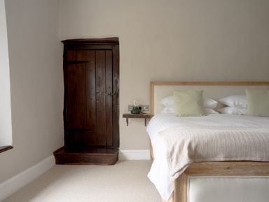 A bedroom with a bed and cupboard at Holwell Farmhouse in Bampton