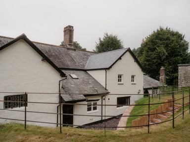 An exterior view of a house with a chimney and steps at Holwell Farmhouse in Bampton