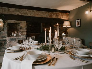 A dining room with table set for a meal at Holwell Farmhouse in Bampton
