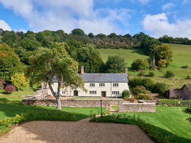 A house with a garden and tree at Holwell Farmhouse in Bampton
