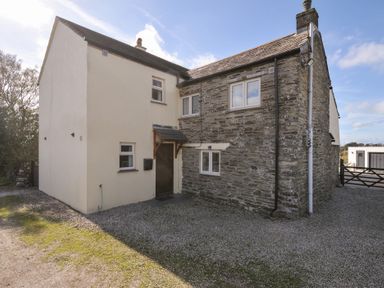 An exterior view of a house with a gravel driveway at Rosewin Farmhouse near St Minver
