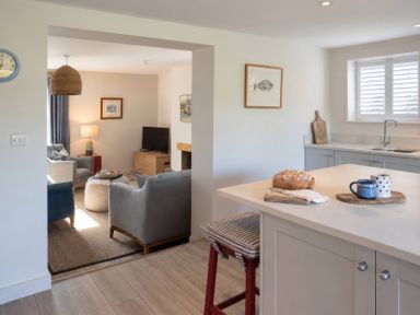 A kitchen with a view of the living area at Wood Cottage