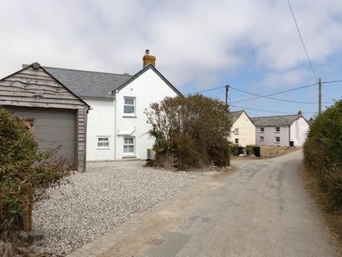 A house and garage on a gravel driveway at Wood Cottage