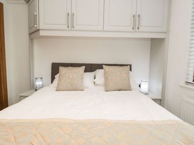 A bedroom with a bed and bedside tables at Easedale Lodge, Waterside Wood 2, White Cross Bay near Windermere