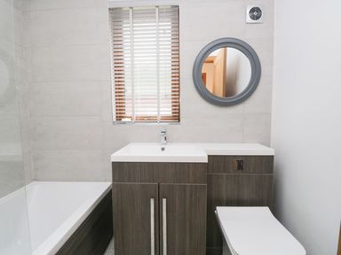 A bathroom with a bathtub, toilet, and vanity unit at Easedale Lodge, Waterside Wood 2, White Cross Bay near Windermere