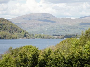 A view of a lake with trees and mountains at Easedale Lodge in Waterside Wood 2, White Cross Bay near Windermere