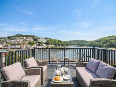 An outdoor seating area with a table and views of water and hills at Overdale