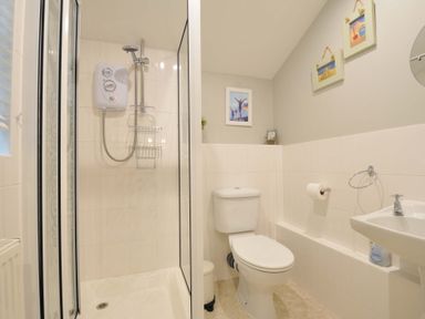A bathroom with a shower, toilet, and sink at Overdale