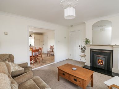 A living room with a sofa, coffee table, and fireplace at Dunbrody Dreams