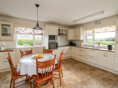 A kitchen with a dining table and chairs at Dunbrody Dreams