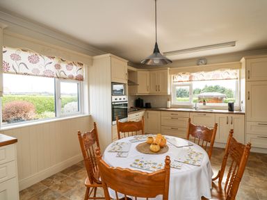 A kitchen with a dining table and chairs at Dunbrody Dreams 